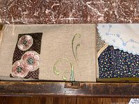 Drawer showing folded linen placemats with floral embroidery and lace-edged napkins.