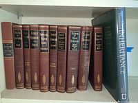 Bookshelf with maroon hardcover forestry textbooks and large blue National Geographic book