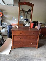 Full front view of the dresser with attached mirror, shows overall design, drawer layout, and wood finish.