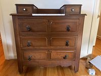 Frontal view of the vintage solid wood dresser showing three large drawers with ornate handles and white marble inset top.
