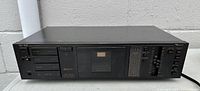 Full front view of the black Nakamichi BX-100 cassette deck showing all buttons, meter and cassette window.