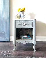 Front view of the French Provincial style night table showing the drawer, cupboard, and leg details.