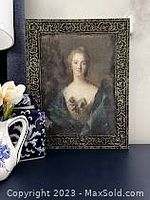 Frontal view of vintage-style portrait wall art featuring a woman's bust and faux ornate frame