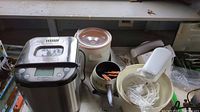 Overview of bread maker, crock pot, and stand mixer placed on a table showing condition and accessories.