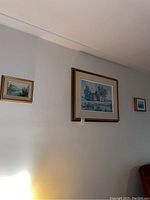 Three framed Keirstead prints hanging on a wall: one large print in center and two smaller on either side
