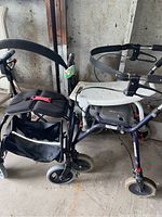 Two rollators side by side, Nexus and Legacy models, along with white resin shower stool in garage.