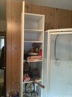 Tall pantry cabinet with one door open showing 5 adjustable shelves inside. Miscellaneous items on shelves not included.