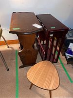 View of vintage wood magazine side table, wood drop leaf side table, and small three-legged stool grouped together