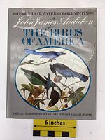 Front cover showing dust jacket with tear on right side, featuring colored bird illustrations and title text.