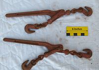 Pair of rusty load binders with hooks, showing length comparison with 6 inch ruler
