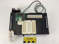 Overall view of homemade electronic breadboard assembly with power supply and multiple breadboards mounted on wooden base with handles and connected wiring.