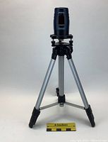 Mastercraft Hawkeye laser level mounted on tripod, front view with scale showing size reference.