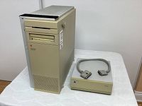 Macintosh Quadra 950 computer tower and external SCSI hard drive on white cloth