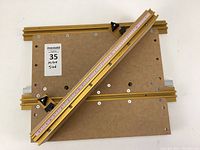 Top view of the mitre sled showing the wooden base plates with aluminum rails and measurement scale for precise cutting.