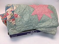 Quilt folded, showing star patchwork and checked backing fabric