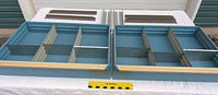 Top photo showing two industrial metal drawers side by side, blue color, each with adjustable internal dividers and mounting brackets behind them.