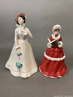 Both Royal Doulton figurines side by side on grey background.
