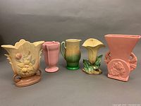 Front view of five assorted vintage pottery pieces grouped together, showing scale and color variety