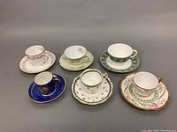 Photo showing all six teacup and saucer sets arranged in two rows