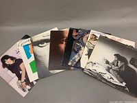 Lot of 8 vinyl records by Chicago, Phil Collins, Genesis, Bread, Billy Joel, Joan Jett arranged side by side showing front album covers.