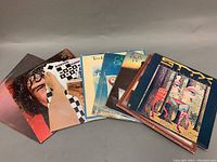 Ten vinyl records displayed in a fan arrangement showing album covers from Cat Stevens, Styx, and Burton Cummings.