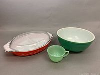 Lot showing all three items: Pyrex green mixing bowl, orange Anchor-Hocking covered casserole dish, and Fire-King jadeite mug.
