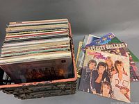 Box filled with approx. 25 assorted vintage vinyl records, showing the spines of many albums.
