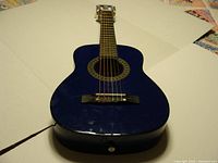 Front view of the blue ADM 30 inch beginner acoustic guitar showing body and strings.