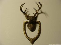 Front view of vintage solid brass 10 point buck door knocker with antlers and ring knocker attached.