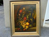 Full view of the framed vintage oil on board painting featuring a still life of flowers, fruits, and a metal jug.