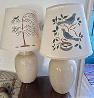 Pair of matching ginger jar style table lamps with Americana shades featuring birds and tree branches.