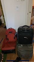 Overview of the full set showing orange backpack on top of one suitcase and two additional suitcases beside them.