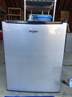 Front view of Whirlpool mini refrigerator showing stainless steel door with Whirlpool logo