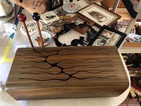 Top view showing wooden tongue drum with elongated slit design and two wooden mallets with black and red heads.
