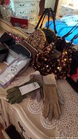 Overall lot showing assorted gloves and purses on a lace-covered surface