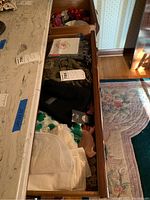 Top drawer with scarves, napkins, and doilies visible, showing a variety of textiles in different colors and materials