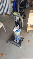 Full view of upright Bissell CleanView Rewind Pet vacuum cleaner with hose and base visible.