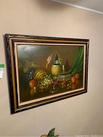 Frontal view of the oil painting showing the full artwork of fruit and wine with a detailed frame