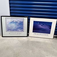 Two framed inspirational posters side by side on floor against blue shutter, titled 'Attitude' and 'Imagination'
