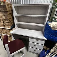 White wood kids desk with attached bookshelf and three drawers shown with chair