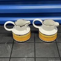 Two Midwinter creamers side-by-side showing the yellow band design and wear