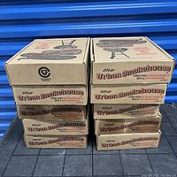 Stack of ten Urban Smokehouse smoker boxes with visible damage and wear