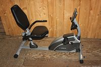 Side view of the Exerpeutic recumbent exercise bike showing the padded seat, backrest, and frame design.