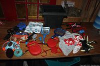 Overview of the lot showing toys, leashes, grooming tools, and a pet shirt on a wooden table.