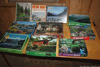 Photo of all nine puzzle boxes showing various scenic and artistic covers placed on wooden surface