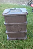 Full view of the square brown plastic rain barrel