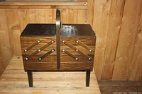 Closed vintage wooden sewing basket with handle and fold out sides