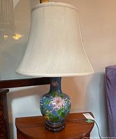 Overall view of lamp on wooden stand with fabric shade