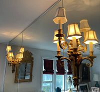 Overall view of sconce mounted on wall with mirrored reflection showing design and scale