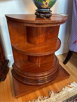 Front view of side table showing three semicircular shelves and rectangular base